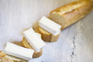 Three pieces of baguette with brie lying on the kitchen table.