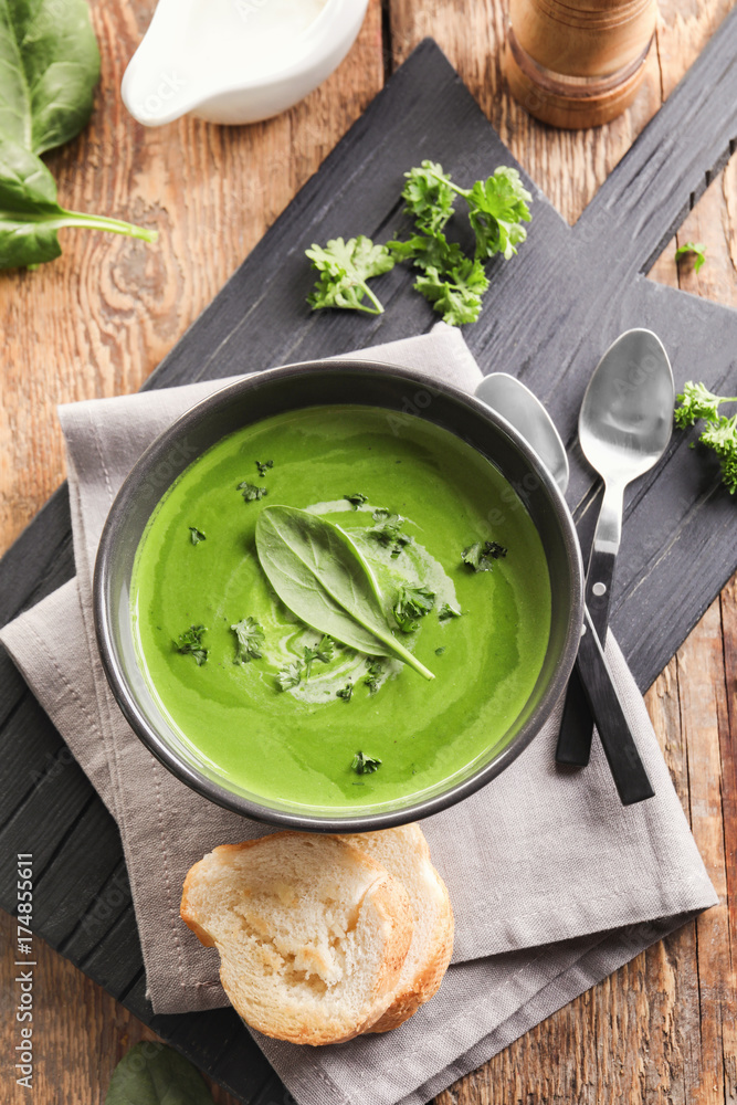 Wall mural bowl with delicious spinach soup on table