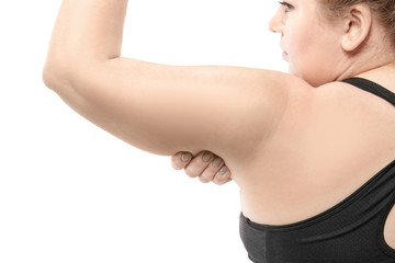 Woman touching fat on her arm against white background. Weight loss concept