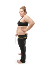 Overweight young woman measuring her hips on white background. Weight loss concept
