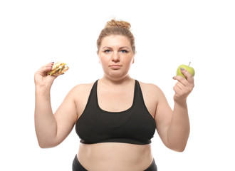 Overweight young woman with burger and apple on white background. Weight loss concept