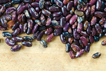 Beans purple and black beans with strips of sorts Railroad, Selugia, Idaho Refuge scattered on a wooden background. Copy space.
