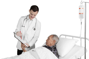 Doctor shows medical report to elderly patient