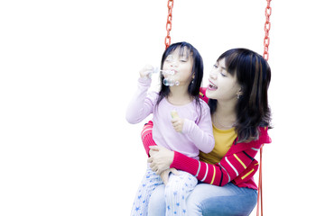 Cute girl with her mother on the swing