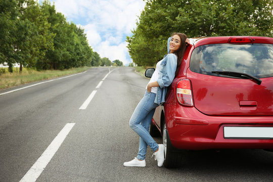 Young Woman Leaning On Car Outdoors