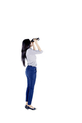 Businesswoman looking through a binocular