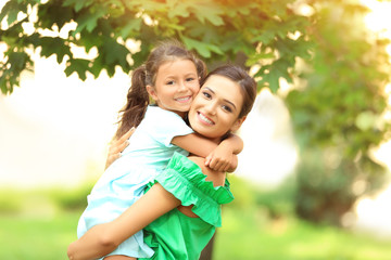 Cute little girl with mother in park on sunny day