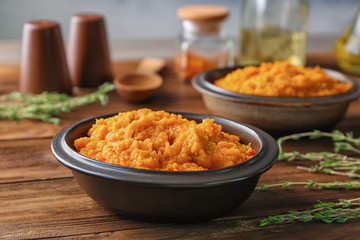 Bowl with mashed sweet potato on wooden table