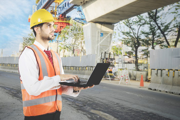Arabian architect with laptop at construction site