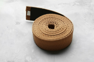 Brown karate belt on grey background