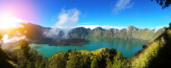 Colorful panorama view of the crater in Rinjani mount in Lombok with sun light, Indonesia on a nice sunny day and blue sky © orientalprincess310