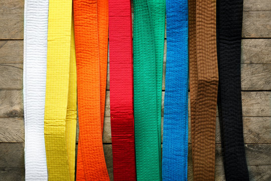 Colorful karate belts on wooden background
