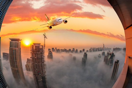 Plane is flying over Dubai against colorful sunset in United Arab Emirates