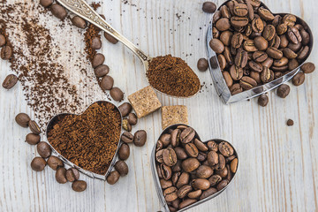 coffee concept/coffee beans and coffee ground in shape heart on light wooden background,selective focus