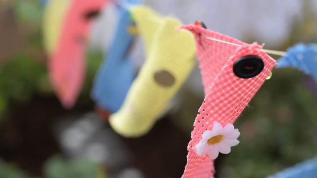 Hand sewn children's bunting blowing in the wind in a garden in summer.