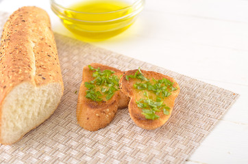 Fried bread with olive oil, garlic and herbs on a wooden table. Rustic style.