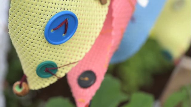 Hand sewn children's bunting blowing in the wind in a garden in summer.