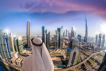 Crédence en verre imprimé Burj Khalifa Arabian man watching cityscape of Dubai with modern futuristic architecture in United Arab Emirates.