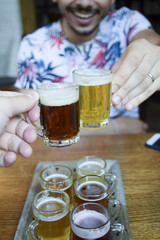 Two men toasting (cheers!) over mini beer