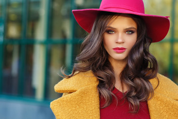 Young beautiful women in a yellow coat and a red hat, outdoor