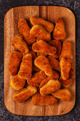 Chicken nuggets with sauces on dark background.