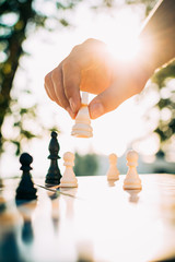 Close up of man hand playing chess outdoors in city, close up