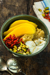 Quinoa porridge with mango, pistachio nuts, goji berries and honey yogurt