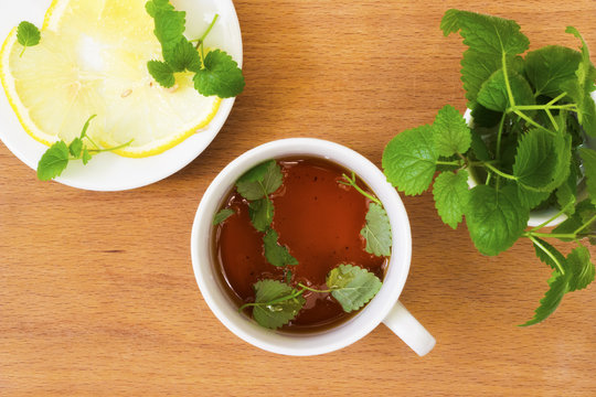 Mint tea with Melissa and lemon on a wooden table