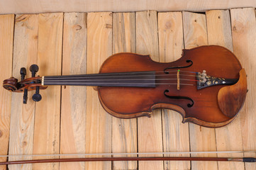 Obraz na płótnie Canvas one violin image .old brown stringed wooden instrument isolated on the wood background and bow