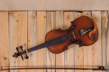 Fototapeta na wymiar one violin image .old brown stringed wooden instrument isolated on the wood background and bow