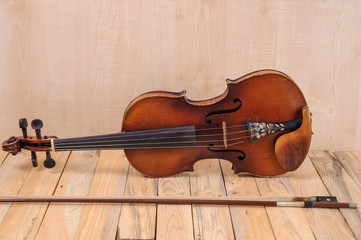 one violin image .old brown stringed wooden instrument isolated on the wood background and bow