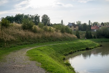 Chimneys of town and clouds with reflections in water reservoir on river Vah. Slovakia