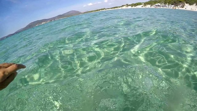 Man swimming in Sardinia turquoise sea, Italy. Slow motion effect