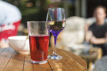 Summer beverages including fruit juice, wine and crisps on a wooden garden table