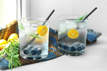 Glasses with fresh rosemary drink on window sill