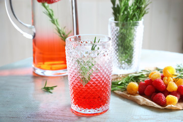 Glass with fresh rosemary drink on table