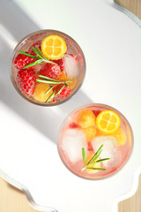 Glasses with fresh rosemary drink on wooden board