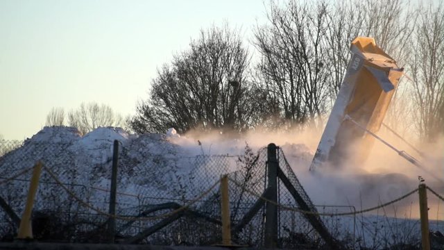 Soda ash being tipped onto a pile on an industrial site.