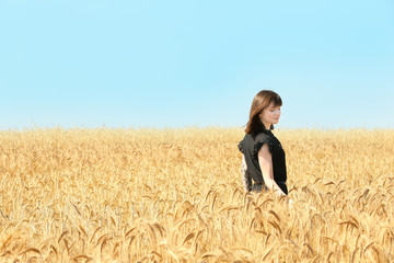 Naklejka na ściany i meble Young woman in wheat field