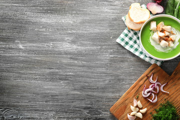 Composition with delicious spinach soup and vegetables on wooden background