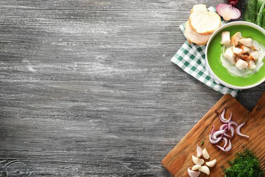 Composition with delicious spinach soup and vegetables on wooden background