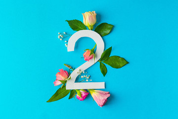 Composition with number 2 and beautiful flowers on color background