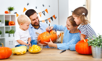 happy family mother father and children cut pumpkin for   halloween