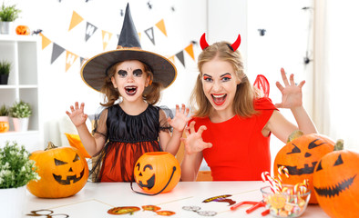 happy family mother and child daughter in costumes   for halloween at home