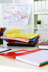 Office table with blank notepad and laptop