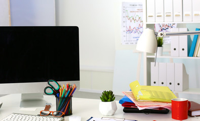 Office table with blank notepad and laptop