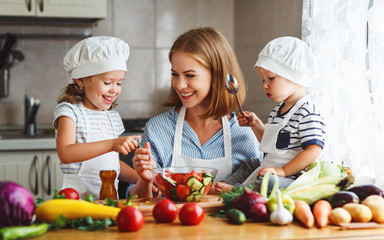 Healthy eating. Happy family mother and children  prepares   vegetable salad