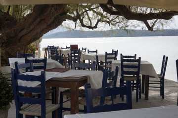 Griechische Taverne unter Bäumen am Meer