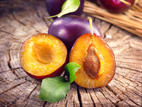 Plum. Juicy ripe organic plums closeup, over wooden background