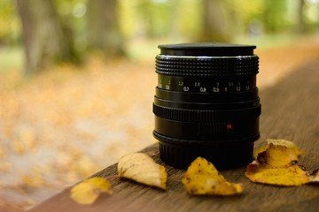 Lens camera on autumn background.